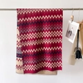 Dettaglio della trama a righe geometriche e frange sulla sciarpa scialle effetto cashmere - Rosso