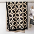 Dettaglio della sciarpa in maglia floreale con frange e una borsa nera per lo styling - Nero