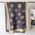 Detail of cashmere-like scarf showing camellia patterns, dual-tone design and soft tassels - Gray