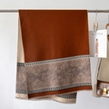Dettaglio dello scialle in cashmere con motivi paisley e bordi a frange morbidi - caffè