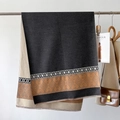 Dettaglio di una morbida sciarpa invernale con motivi jacquard geometrici e frange - grigio scuro