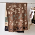 Dettaglio di sciarpa invernale marrone con stampe di foglie e bordi con frange fini - 66*186cm / Marrone