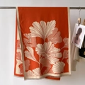 Dettaglio di pashmina arancione con motivo a foglie di ginkgo bianco e nappe fini - Arancione