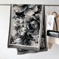 Dettaglio di uno scialle pashmina invernale con stampa floreale e frange fini - Nero e Grigio