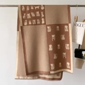 Detail of soft brown knit scarf featuring cartoon cat prints and houndstooth pattern - Khaki