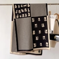 Detail shot of winter scarf featuring cat illustrations, houndstooth pattern and fringes - Black