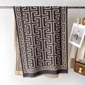 Dettaglio di una sciarpa nera e beige con motivo a greca e morbide frange per l'inverno - 66*186cm / Grigio