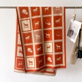 Detailaufnahme des Winterschals mit Karomuster, Pferdemotiv und weichen Fransen - Orange
