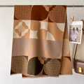 Dettaglio dello scialle effetto cashmere con motivi a quadri e morbide nappe a frangia - Cachi