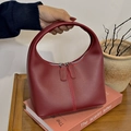 Sac à main élégant en cuir souple rouge vin avec chaîne et design aux courbes fluides - Rouge