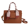 Brown lychee grain tote bag with silk scarf handle and gold hardware on white background - Brown