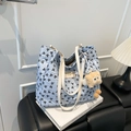 Light blue tote bag with black bow patterns and a yellow plush charm on white book box - With Charm / Blue