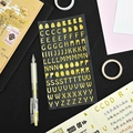3D gold foiled alphabet stickers set featuring embossed uppercase letters on black background - Gold Cartoon Letters