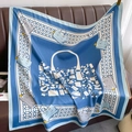 Elegant blue silk square scarf with luxury fashion accessories print draped on a sofa - Blue