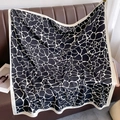 Dettaglio di un grande foulard quadrato in raso bianco e nero drappeggiato sul divano - Nero