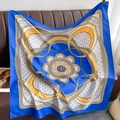 Dettaglio foulard in seta blu reale con stampa catena dorata su divano in pelle - Blu
