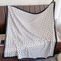 Detailed view of silk scarf with polka dots and C pattern on a leather background - 90*90cm / White