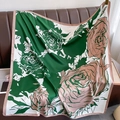 Dettaglio di un foulard in seta verde smeraldo con stampe di rose rosa su pelle - Rosa e Verde