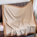 Carré en soie à motifs géométriques et bordures camel sur un canapé en cuir brun - 90*90cm / Kaki