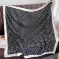 Détail d'un grand foulard carré en soie avec motif de lettres sur canapé en cuir brun - 90*90cm / Noir