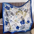 Detail of floral silk scarf with tropical leaves draped over a brown leather sofa - 90*90cm / Dark Blue