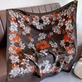 Détail d'un foulard en soie vintage à fleurs drapé sur un canapé en cuir chic - Grandes Fleurs Oranges (XW-47)
