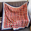 Close-up of geometric pattern silk scarf with Lucky lettering on a leather background - 90*90cm / Red