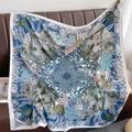 Detail of tropical jungle print silk scarf draped on a dark brown leather sofa - Milan Color (XW-45)