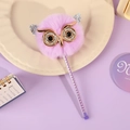 Macro di una penna a gufo in peluche viola con occhiali dorati su vassoio - Gufo Viola