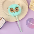 Dettaglio di una penna gufo di peluche verde menta con occhi glitterati su un vassoio - Gufo Verde