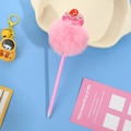 Detail of pink faux fur ball pen with a sweet cake topper decoration on a blue surface - Pink