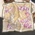Vue détaillée d'un foulard en soie à fleurs sur tapis en peluche et décor vintage - Style Orchidée Bordure Verte Or Champagne (ZC-226) / 65x65cm