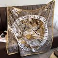 Detail van luxe zijden sjaal met vintage zon- en maanprint op een lederen bank - Gele Rand