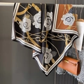 Détail d'un foulard en soie avec motif camélia et imprimé chaîne dorée en orange et noir - Café Noir