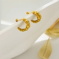 Detail of gold C-shaped quilted hoop earrings with polished croissant texture on white stand - Multi-Section Croissant