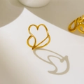 Dettaglio dell'anello a cuore in oro 18K con design a linee curve e silhouette traforata - US 6 / Stile Cuore Vuoto