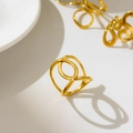 Dettaglio dell'anello d'oro curvo traforato con design a linee incrociate lucide - US 6 / Stile Croce X