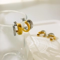 Close-up of two-tone C-shape earrings with polished gold and silver finish hanging on glass - Curved Hollow (Two-tone) / Diameter 1.8cm