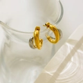 Macro detail of two-tone C-shape curved earrings in gold and silver on a glass edge - Long + Short Curve (Two-tone) / 1.7cm Diameter