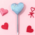 Blauer Herz-Kugelschreiber mit Schleife und silbernen Perlen auf rosa Hintergrund - Blau