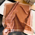 Detalle de un pañuelo de seda con patrones geométricos naranjas y bordes de satén rosa - Naranja