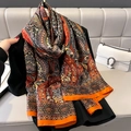 Elegante zijden sjaal met oranje paisley-print gedrapeerd over een zwarte gebreide top - 180x90cm / Oranje Rand Paisley Print Stijl (F-124-1)