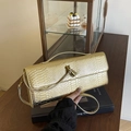 Golden snake-embossed crossbody bag with metallic texture and bamboo-style twist lock - Gold