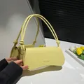 Minimalist bright yellow underarm bag with litchi grain texture and knotted strap - Yellow