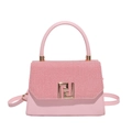 Pink trapezoid crossbody bag with woven texture lid and golden hardware in front view - Pink