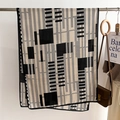 Dettaglio della sciarpa geometrica bianca e nera con motivo a scacchi su gruccia - 66*178cm / Beige-Nero