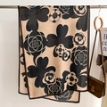 Detail van de beige sjaal met camelia-print gedrapeerd over een houten hanger - 66*178cm / Khaki (FSM-7)