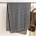 Detail van grijze sjaal met Grieks geometrisch patroon aan een hanger met accessoires - Blauw