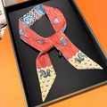 Close-up of silk twilly ribbon featuring red seahorse patterns on orange gift box - 5*85cm / Rose Red