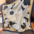 Détail d'un foulard en soie à motif camélia drapé sur un canapé en cuir rétro - 90*90cm / Jaune
